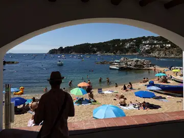 Varias personas disfrutan del buen tiempo en la playa de Calella de Palafrugell Varias personas disfrutan del buen tiempo en la playa de Calella de Palafrugell