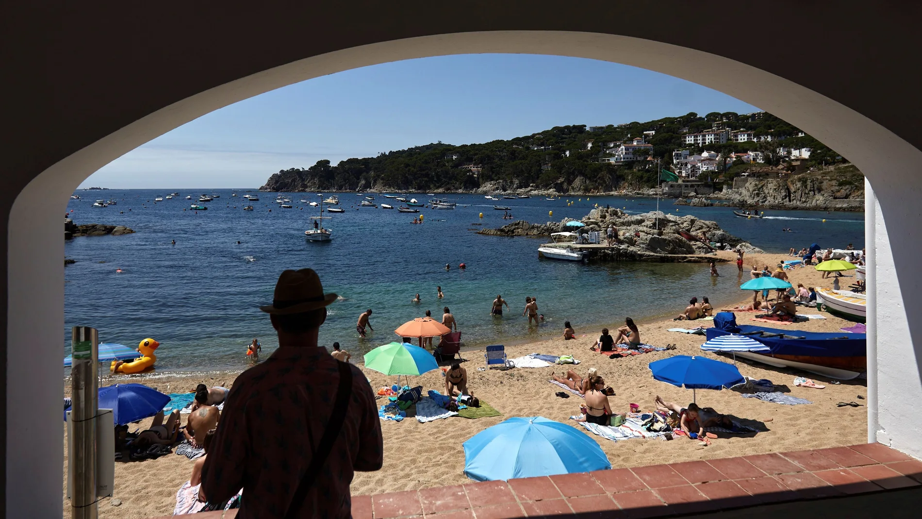 Varias personas disfrutan del buen tiempo en la playa de Calella de Palafrugell