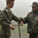 Foto de archivo en la que se ve a un soldado chino (a la izquierda) y a otro soldado indio colocando una concertina en la frontera en Sikkim