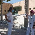 Dos sanitarios conversan en las inmediaciones del polideportivo Cortes de Aragón de Fraga, Huesca