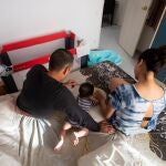 Claudia, Johnny y el pequeño Gareth, de cinco meses, en la habitación en la que viven. Reciben una ayuda de Cáritas para comprar alimentos y se les fue asignada una trabajadora social para seguir su caso.