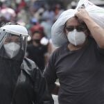 People wearing masks and face shields walk in the capital's downtown amid the new coronavirus pandemic in Quito, Ecuador, Monday, June 29, 2020. (AP Photo/Dolores Ochoa)