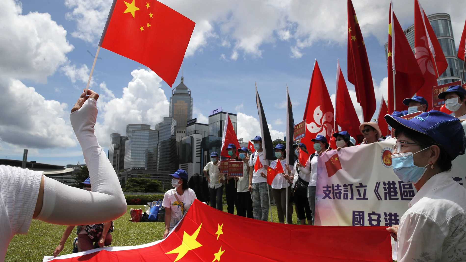 Manifestantes pro China ondean banderas para celebrar la aprobación de la Ley de Seguridad
