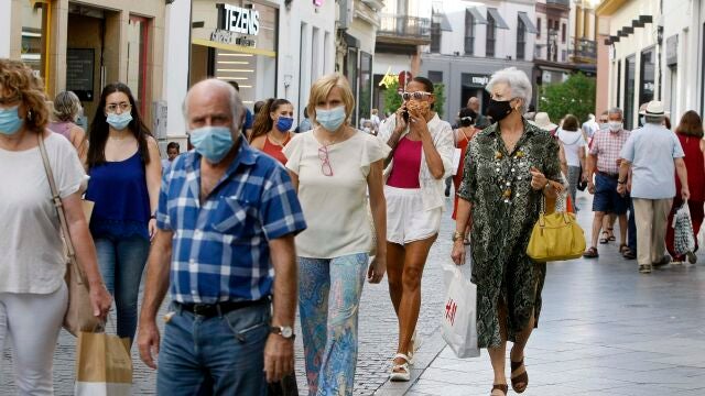 Transeúntes paseando por una calle de Sevilla tras el fin del estado de alarma