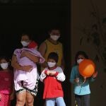 A family takes a walk in the garden of a religious property being used as a government-run shelter where citizens returning home are required by law to quarantine for two weeks and pass two consecutive COVID-19 tests, as a preventive measure amid the COVID-19 pandemic on the outskirts of Asuncion, Paraguay, Thursday, June 18, 2020. While Paraguay appears to be controlling the disease, it faces concerns about a predicted 5% drop in gross domestic product for an economy that was already struggling, and a health system that remains unprepared for a large-scale epidemic. (AP Photo/Jorge Saenz)
