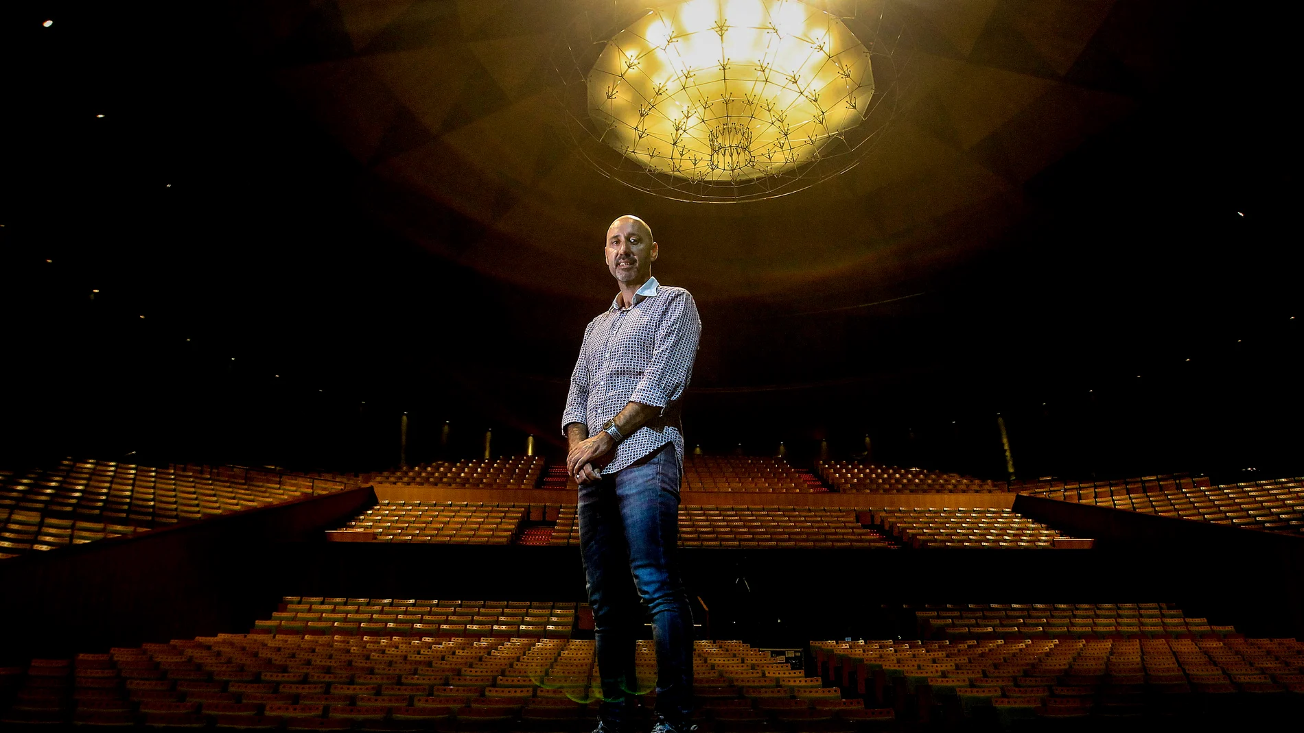 El responsable del teatro sevillano posa sobre el escenario, con el patio de butacas completamente vacío