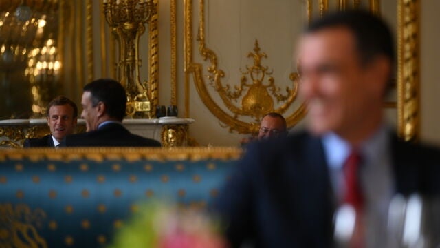 El presidente del Gobierno, Pedro Sánchez (d) y el presidente de la República Francesa, Emmanuel Macron (reflejado en el espejo), en el Palacio del Elíseo, el miércoles