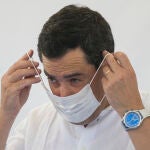 Imagen de archivo del presidente de la Junta de Andalucía, Juanma Moreno, colocándose una mascarilla