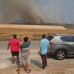 Varias personas observan el avance de las llamas del incendio forestal que se ha declarado entre las localidades alicantinas de Monóvar y La Romana. Medios aéreos y terrestres trabajan en la extinción del incendio y que ha obligado a establecer la situación 1 del Plan Especial de Incendios Forestales por la proximidad de algunas viviendas diseminadas