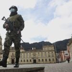 A soldier wearing a protective face mask walks in Bolivar Square in Bogota, Colombia, Tuesday, July 21, 2020, amid the new coronavirus pandemic. (AP Photo/Fernando Vergara)