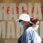 Viandantes caminan por Madrid protegidos con mascarilla, este martes.