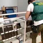 Imagen de un guardia civil en la operación en la que se ha desmantelado una red dedicada a la estafa nigeriana de venta online