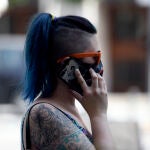 Una mujer con mascarilla habla por teléfono, en Madrid (España) a 30 de julio de 2020. - Óscar Cañas - Europa Press