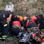 Sanitarios y bomberos atienden al hombre que se ha caído en Benilloba.
