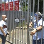 An electoral official, right, tells a voter that the ballots haven't arrived at a voting center in Carolina, Puerto Rico, Sunday, Aug. 9, 2020. Puerto Rico's primaries were marred on Sunday by a lack of ballots in a majority of centers across the U.S. territory, forcing frustrated voters who braved a spike in COVID-19 cases to turn around and go back home. (AP Photo/Danica Coto)