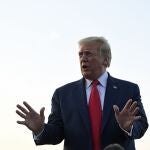 President Donald Trump talks with reporters before departing from Morristown Municipal Airport in Morristown, N.J., Sunday, Aug. 9, 2020. Trump is returning to Washington after spending the weekend at the Trump National Golf Club. (AP Photo/Susan Walsh)