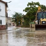 Un tractor limpia las calles de Cebolla (Toledo) cubiertas por el lodo tras las lluvias caídas en la región