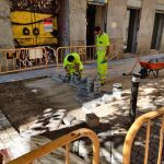Unos operarios ponen los adoquines en una de las calles del centro de Madrid