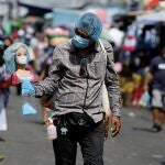 AME8021. SAN SALVADOR (EL SALVADOR), 13/08/2020.- Un hombre que se dedica al comercio informal vende gorros quirúrgicos el 22 de julio de 2020, en San Salvador (El Salvador). Tras cinco meses de confinamiento e intentos de desescalada, Centroamérica sufre un recrudecimiento de la pandemia, con Panamá como el peor escenario, en medio de un creciente deterioro económico y social en una región afectada por una extrema pobreza crónica. EFE/Rodrigo Sura
