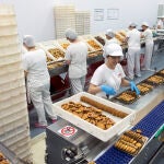 Las trabajadoras seleccionan los productos en la cadena de producción de la fábrica de dulces "Dulca"