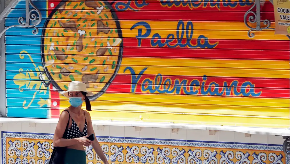 Una persona pasa ante un establecimiento cerrado de paellas cuando el turismo valenciano perderá este año 11.397 millones de euros, lo que supone una caída del 63 % respecto a 2019, según los cálculos de Exceltur, que precisa que la Comunitat Valenciana y Andalucía, que tienen mayor presencia de demanda española, sufrirán unas caídas "algo menos intensa" que el resto de autonomías