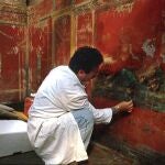 Un arqueólogo trabaja en una de las pinturas conservadas en Pompeya