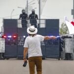 Un manifestante enarbola una bandera frente a un cordón policial en Minsk