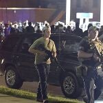 Kyle Rittenhouse, a la izquierda con un rifle de asalto con otro compañero camino por la calle Sheridan de Kenosha en Wisconsin