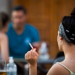 Una mujer sostiene un cigarrillo en una terraza del barrio madrileño de La Latina | Fotógrafo: Jesús G. Feria
