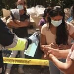 Un sanitario proporciona gel hidroalcohólico a varias personas que esperan en el dispositivo para realizar PCR aleatorias para detectar asintomáticos de Covid-19 en la Comunidad de Madrid, en el distrito de Puente de Vallecas, el pasado 29 de agosto.