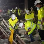 Varios operarios trabajan en las obras que Adif está ejecutando para la nueva configuración del esquema de vías de ancho de vía convencional de la estación de Barcelona-Sants