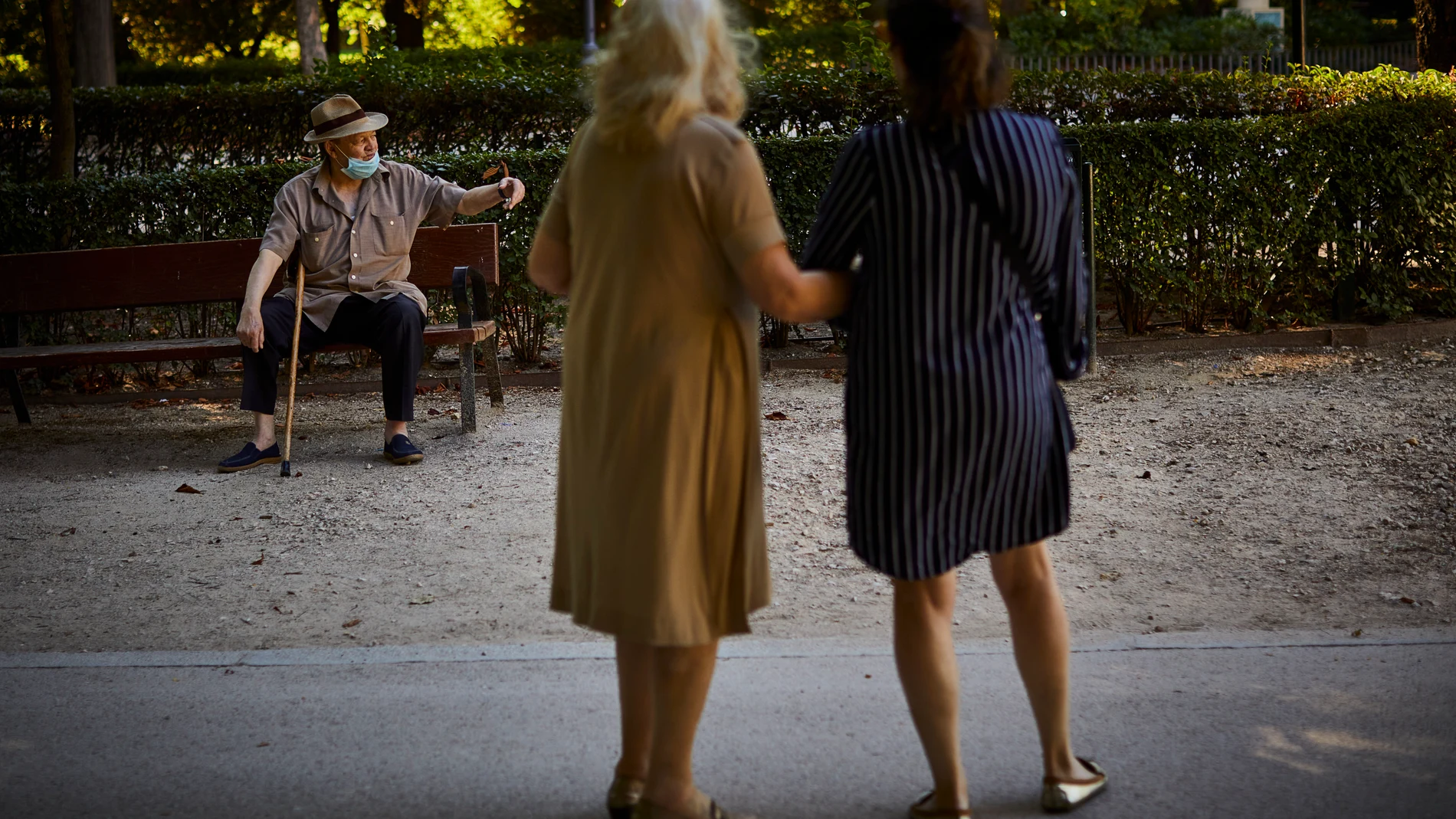 Una persona mayor descansa en un banco