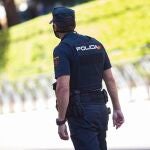Un agente de la Policía Nacional, de espaldas, en servicio, en Madrid