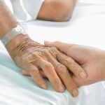 Hospital patient hands to care on bed.