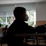 Un niño con mascarilla en un aula