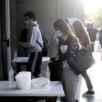 Una alumna se desinfecta las manos antes de entrar al aula de examen de la Facultad de Derecho de la Universidad Complutense para examinarse de la EVAU