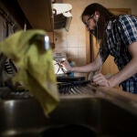 Raúl Sainz-Ezkerra teletrabajando desde su casa con un portátil mientras cocina, en Madrid (España)
