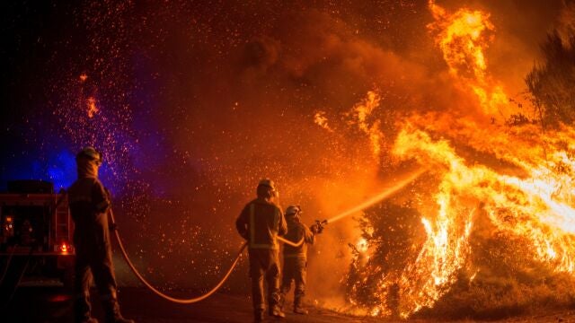 Varios bomberos forestales realizan labores de extinción en el incendio forestal de Cualedro (Ourense)