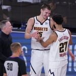 Nikola Jokic y Jamal Murray se saludan en presencia de su técnico Mike Malone