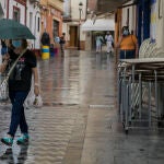 Una mujer se protege de la lluvia bajo su paraguas 