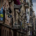 Una mujer toma el aire desde un balcón del barrio del Raval de Barcelona. (AP Photo/Emilio Morenatti)