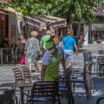 Una camarera limpia una mesa de una terraza de un bar en Benidorm