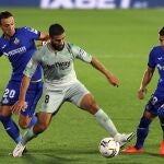 El delantero del Betis Nabil Fekir (c) juega un balón entre Arambarri (d) y Maksimovic, ambos del Getafe