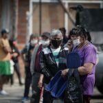 AME8259. BUENOS AIRES (ARGENTINA), 30/09/2020.- Personas usan tapabocas hoy mientras hacen fila para obtener alimentos en un comedor comunitario, en una villa de la Ciudad de Buenos Aires (Argentina). Argentina difunde este miércoles el porcentaje de la población que en el primer semestre del año estaba bajo la línea de pobreza, una situación que ya en diciembre del año pasado sufría el 35,5 % y que se espera haya aumentado por los efectos de la cuarentena por el coronavirus decretada en marzo, aún vigente. EFE/JUAN IGNACIO RONCORONI