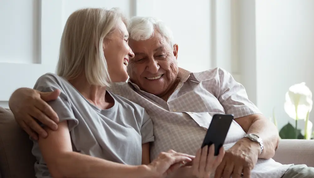 Personas de la tercera edad usando un teléfono móvil