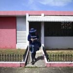 Postal worker Jose Montoya does his rounds in Carolina, Puerto Rico, Thursday, Oct. 1, 2020. More than half of all homes in Puerto Rico lack a physical address, so the absence of street names and numbers also have created multiple problems ranging from ambulances unable to reach a home in time to a delay in the distribution of aid after Hurricane Maria and a string of recent earthquakes. (AP Photo/Carlos Giusti)