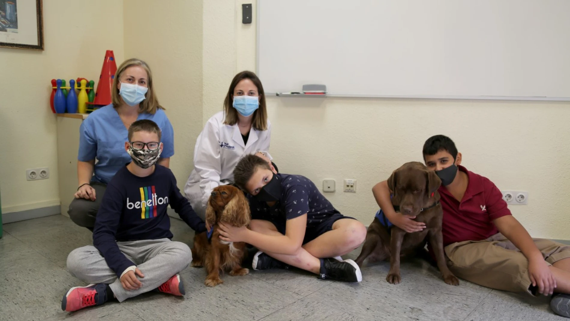 En la imagen, niños con perros, por la terapia