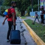 AME636. SAN CRISTÓBAL (VENEZUELA), 12/10/2020.- Un grupo de venezolanos camina por una calle con maletas y bolsos, el 7 de octubre de 2020, en San Cristóbal, estado Táchira (Venezuela). Dejarlo todo sigue siendo la opción de cientos de venezolanos que, agobiados por la pobreza extrema, recorren hasta más de mil kilómetros andando con la esperanza de salir del país, así esto implique días de caminata y un cúmulo de riesgos en la vía. EFE/ Johnny Parra