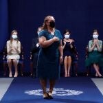 María Jesús Amaro Martín, del servicio de limpieza del Hospital Universitario Central de Asturias, recibe una ovación en representación de sanitarios y familiares de personal sanitario que tuvieron que hacer frente a la COVID-19 tras recibir el Premio Princesa de Asturias de la Concordia durante la ceremonia de entrega de los Premios Princesa de Asturias, este viernes en la antigua capilla del Hotel Reconquista de Oviedo.
