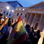 Varios ciudadanos se concentran ante el Congreso de los Diputados con banderas de España, este miércoles, antes de que Vox presente la moción de censura contra el Gobierno de Pedro Sánchez en la Cámara Baja. EFE/Mariscal